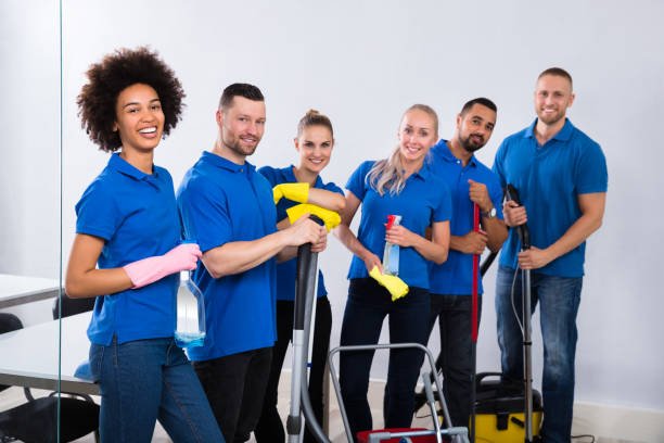 Portrait Of Happy Male And Female Janitors With Cleaning Equipment