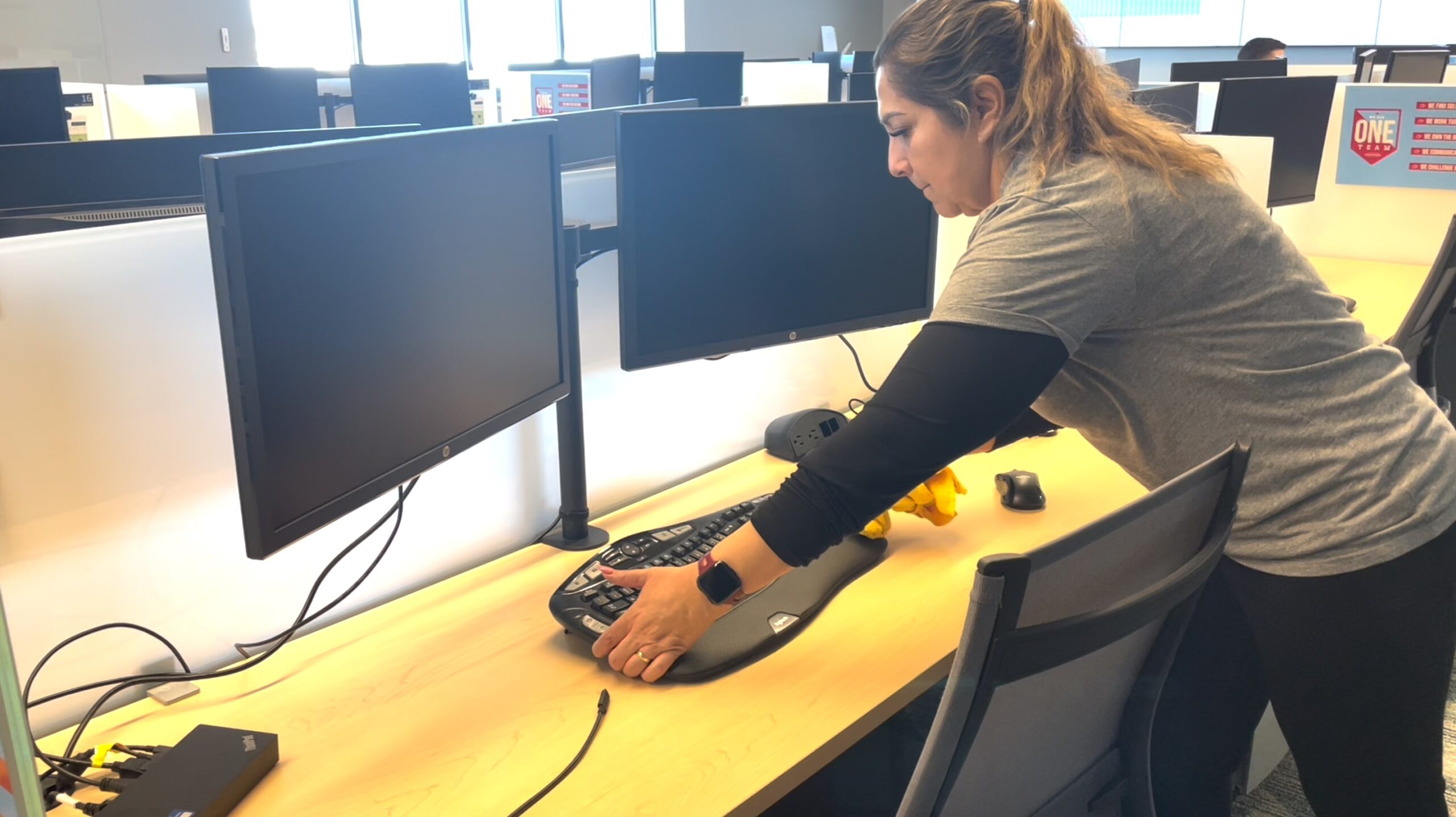 lady staff cleaning the computers in an office