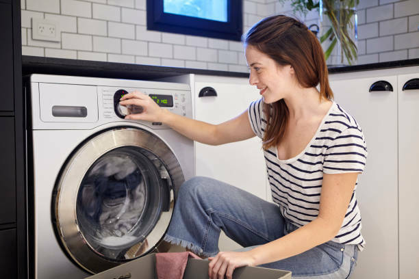 Smiling woman doing laundry at her home