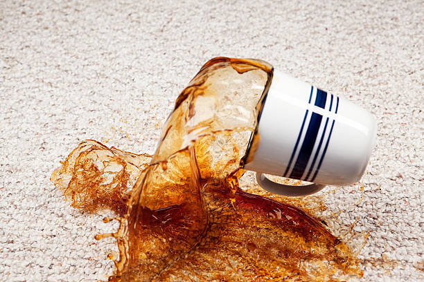 A coffee cup has fallen and coffee is splashing from the cup onto a clean carpet floor. Focus is on the carpet below the cup, at 100% the cup is slightly soft.