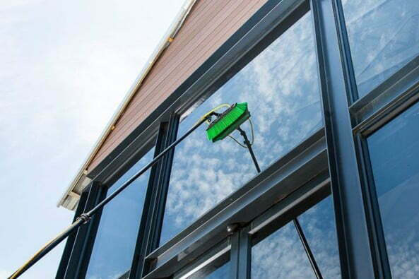 Green Brush Cleaning The Outside Windows of An Office 3 by 2 ratio