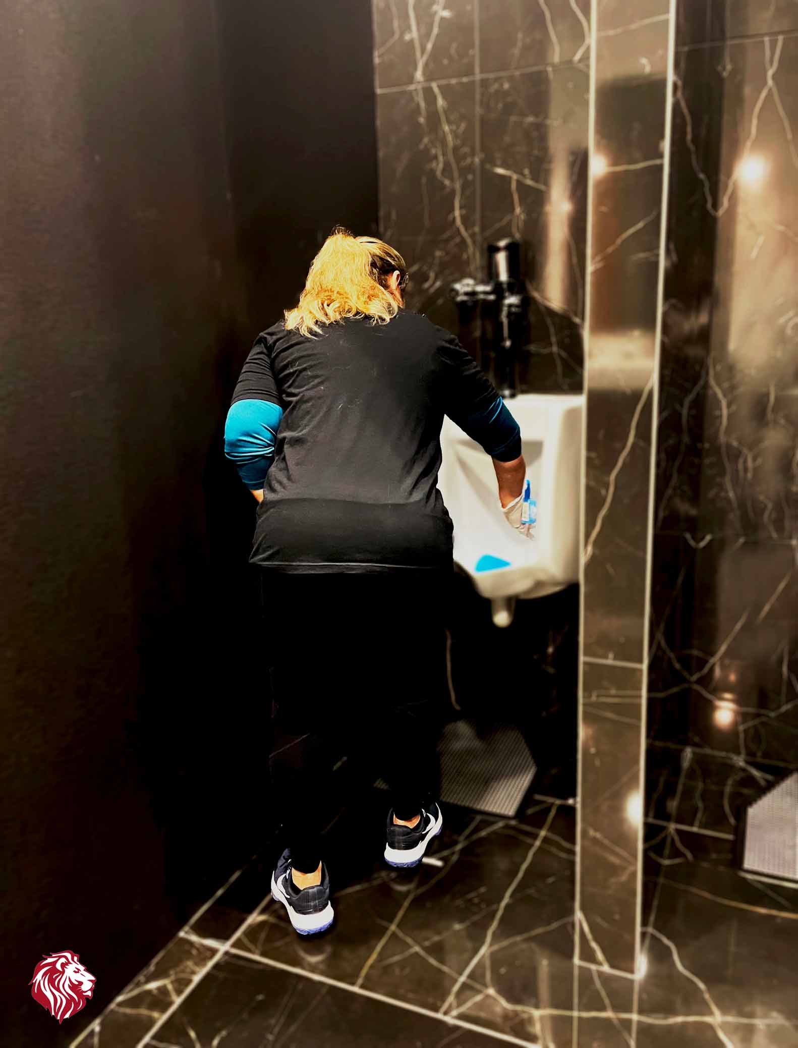 vertical-photo-of-female-staff-cleaning-the-urinal-in-the-bathroom